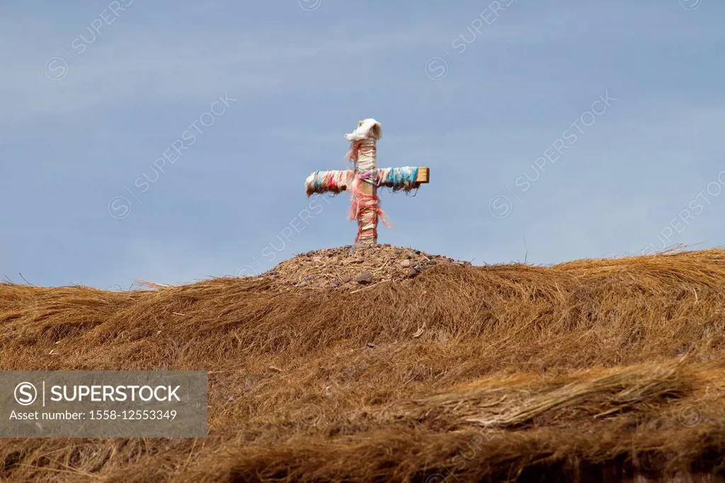 Cross with ribbon on a straw roof in the Atacama Desert, Chile