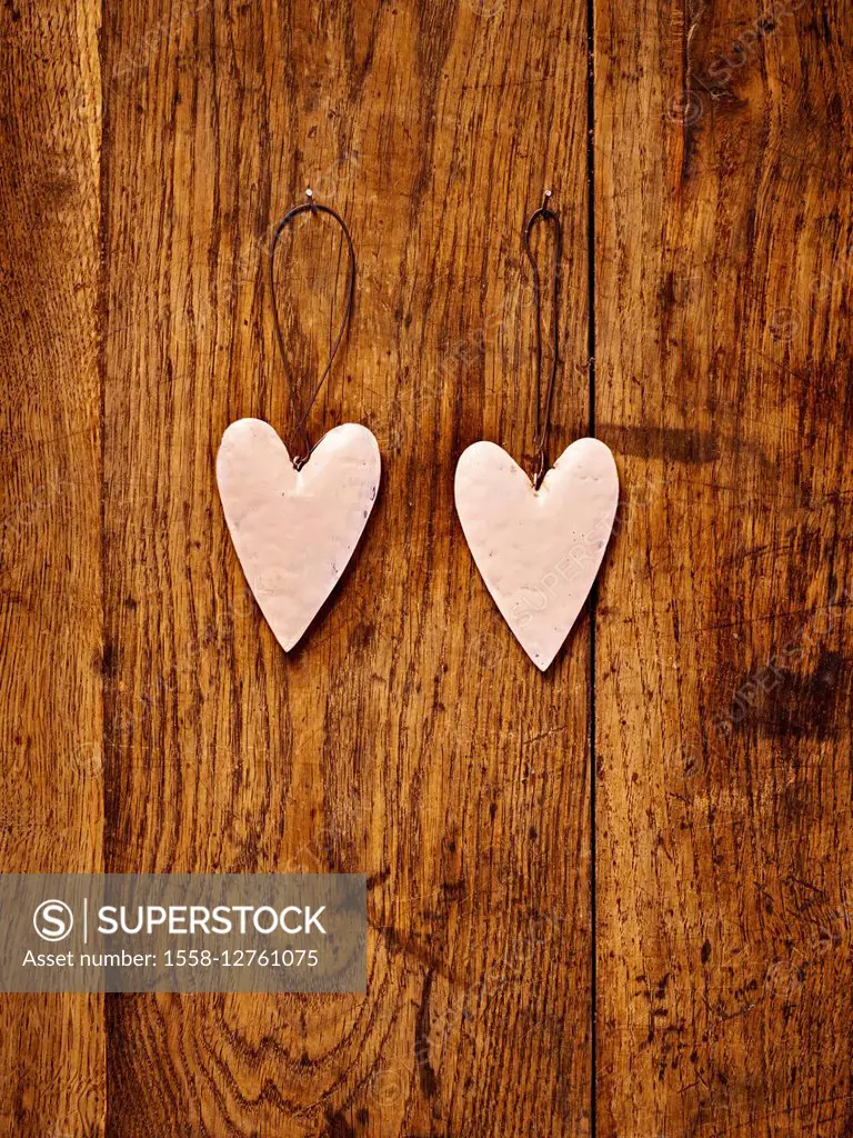 two sheet metal hearts on a brown table