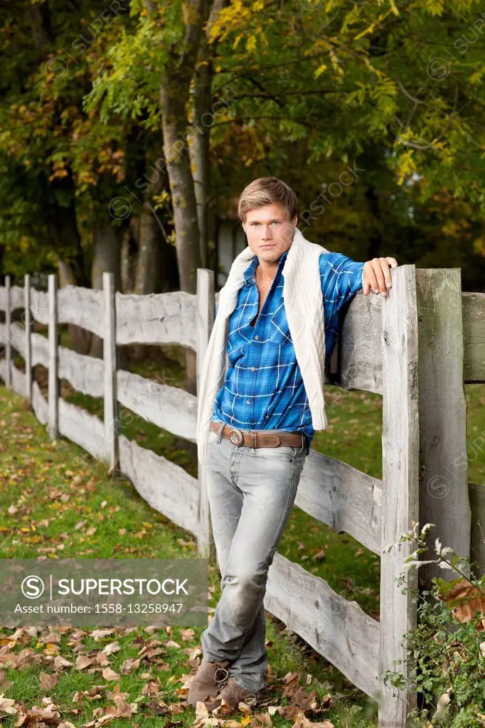 Man leaning against fence