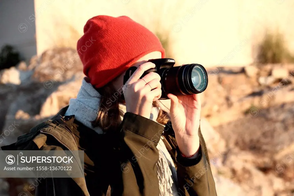 Woman with red beanie photographed with DSLR camera