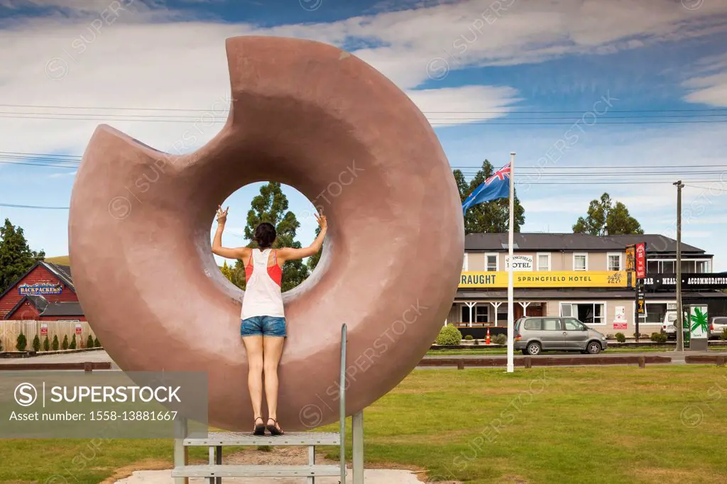 New Zealand, South Island, Selwyn District, Springfield, large donut sculpture with young woman