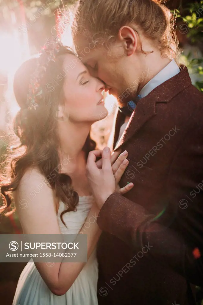 Bride and groom at alternative wedding celebration outside, half profile