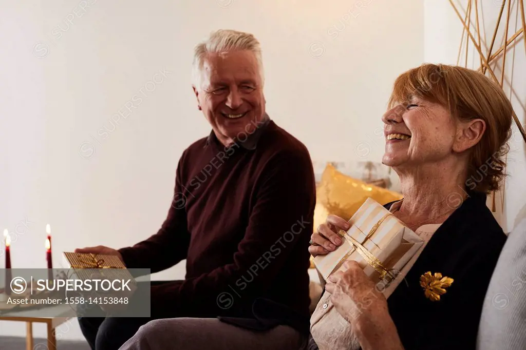 Senior couple with Christmas presents and Christmas wreath