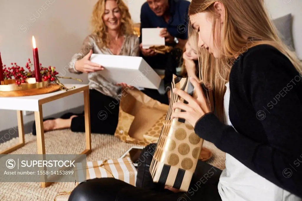 Family at Christmas Eve, unpacking presents,