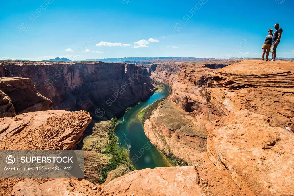 Tourists standing on top of the Horseshoe bend on the Colorado river at the south rim, Arizona, USA