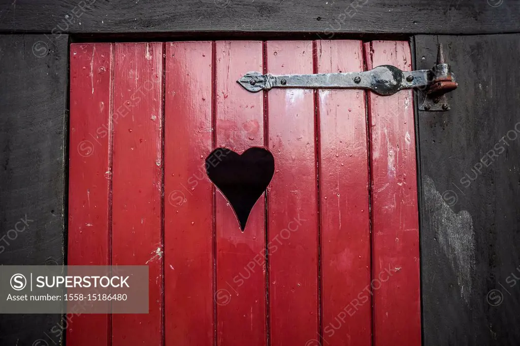 Detail of a red toilet door with heart