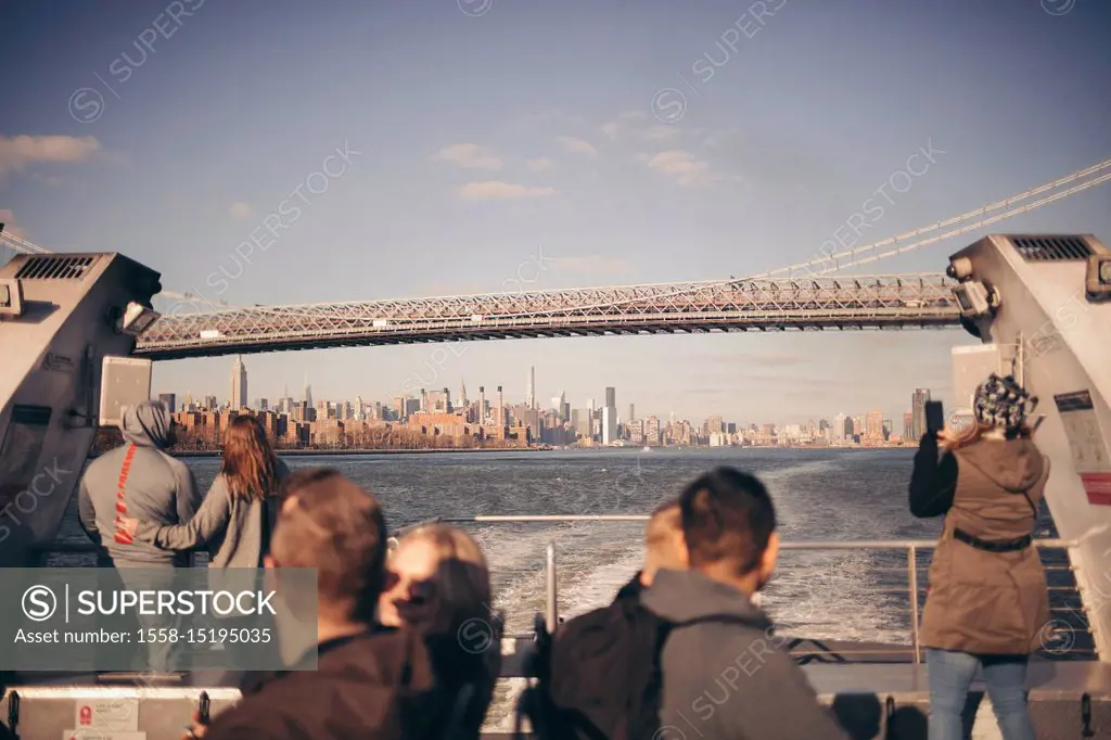 tourists taking pictures from a ferry in brooklyn