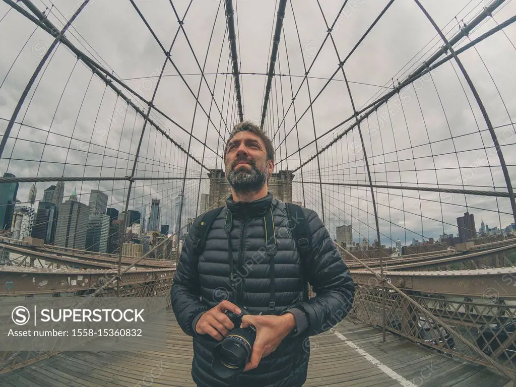 tourist man on Brooklyn bridge in nyc