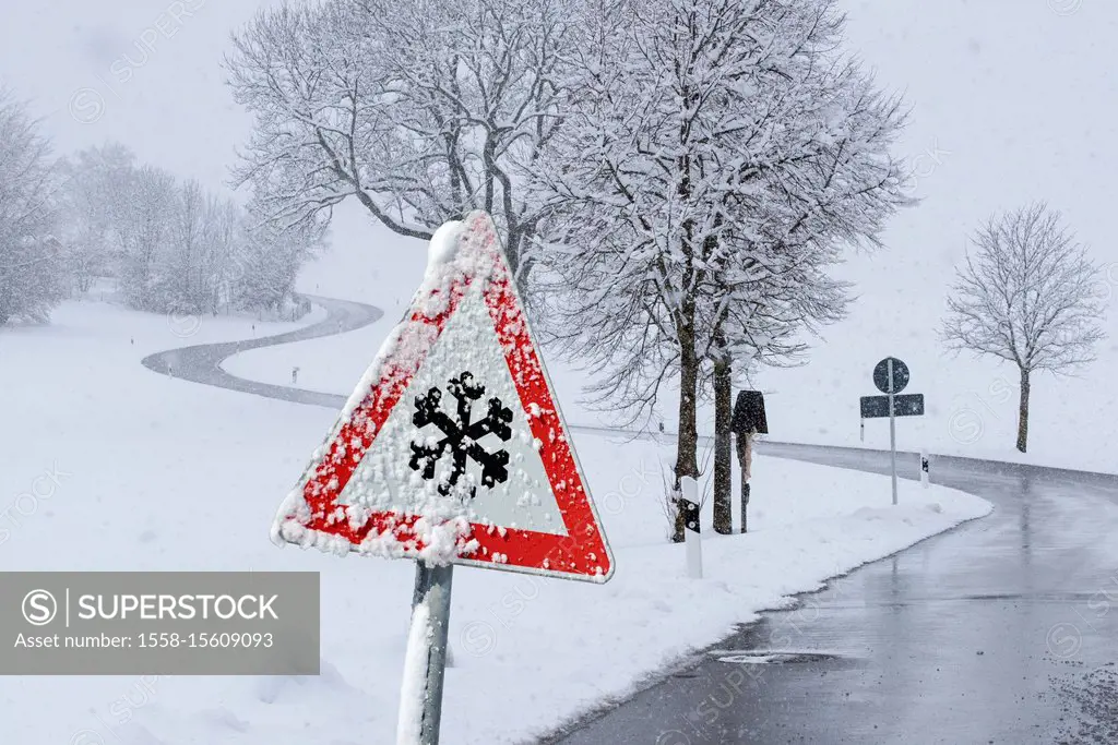 Warning sign of hard-packed snow on road