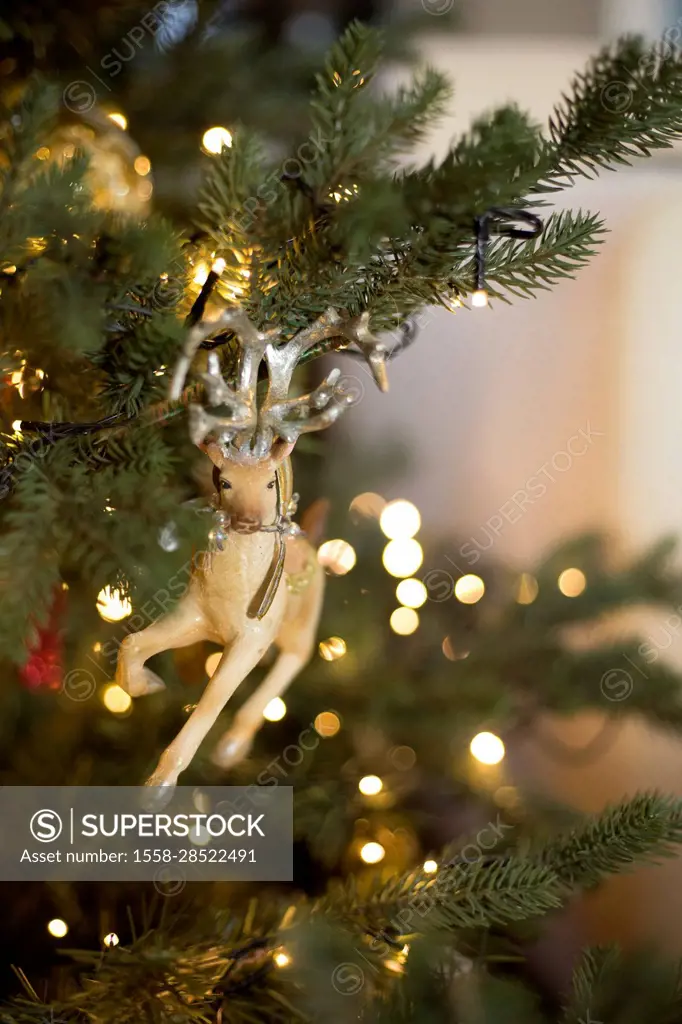 Christmas tree figurine in the shape of reindeer in lighted Christmas tree