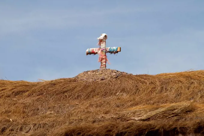 Cross with ribbon on a straw roof in the Atacama Desert, Chile