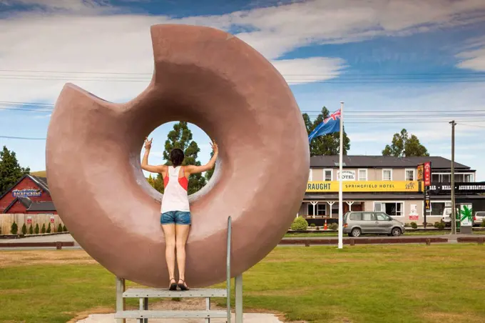 New Zealand, South Island, Selwyn District, Springfield, large donut sculpture with young woman