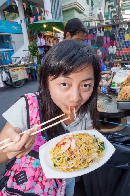 Thailand, Bangkok, Khaosan Road, Female Asian Tourist Eating Pad Thai