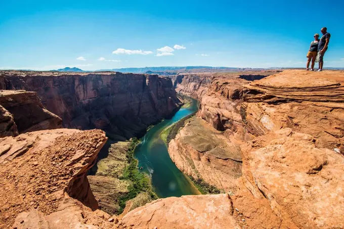 Tourists standing on top of the Horseshoe bend on the Colorado river at the south rim, Arizona, USA