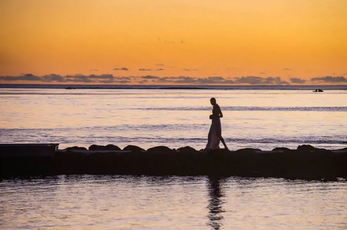 Woman walking on a pier at sunset, Papeete, Tahiti, French Polynesia