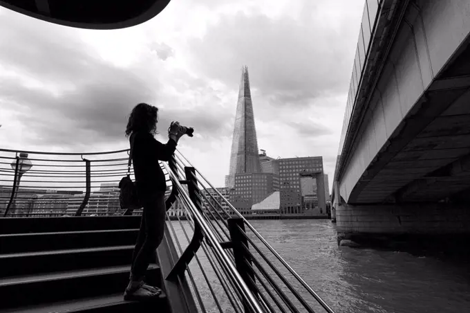 A tourist photograph the London Bridge with shard on the background, London, Great Britain, UK