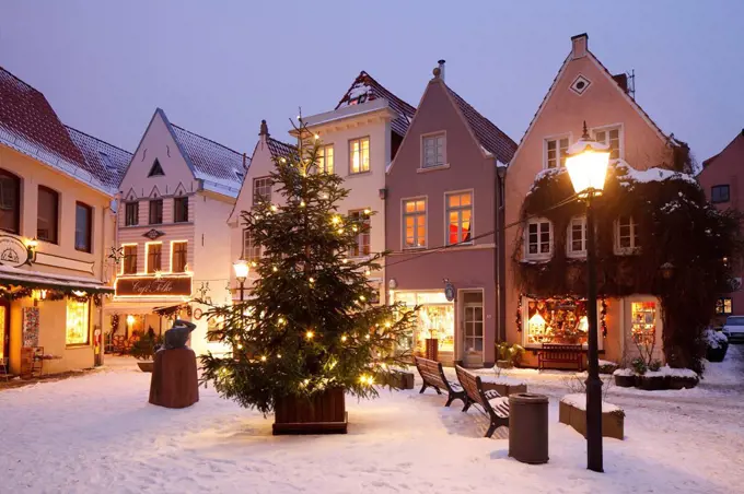 Old houses with snow and Christmas lights on the Stavendamm with Christmas tree in Schnoorviertel, Bremen, Germany, Europe