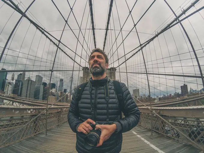 tourist man on Brooklyn bridge in nyc