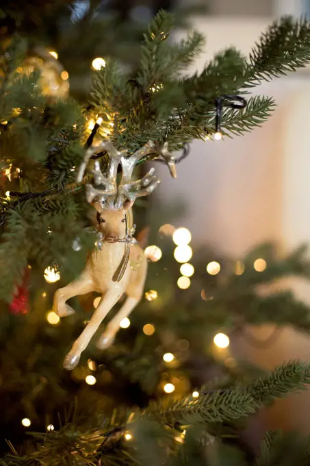 Christmas tree figurine in the shape of reindeer in lighted Christmas tree