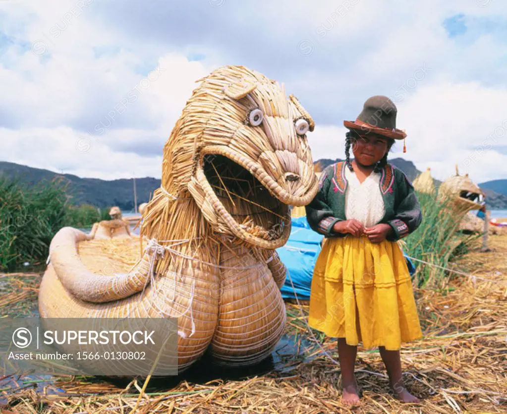 Uru indian girl and totora reeds boat. Titicaca Lake. Peru