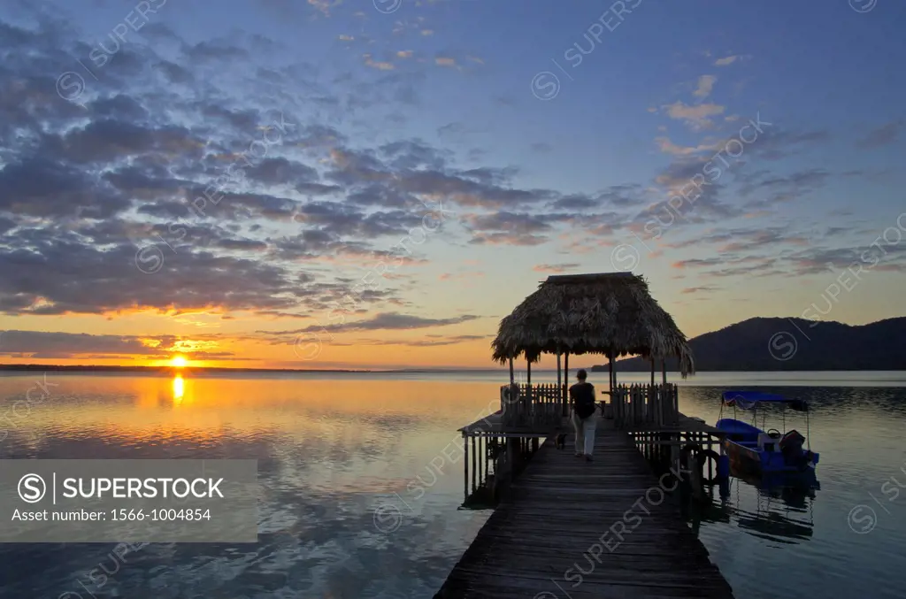 Sunset at dock in the shores of Lake Petén Itza, with Cerro Cahuí in the background, Peten, Guatemala