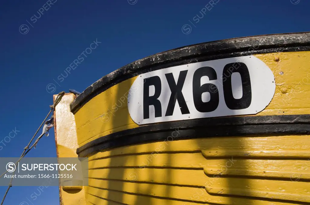 Detail of small yellow wooden fishing boat moored on the beach at Hastings, East Sussex, England, UK