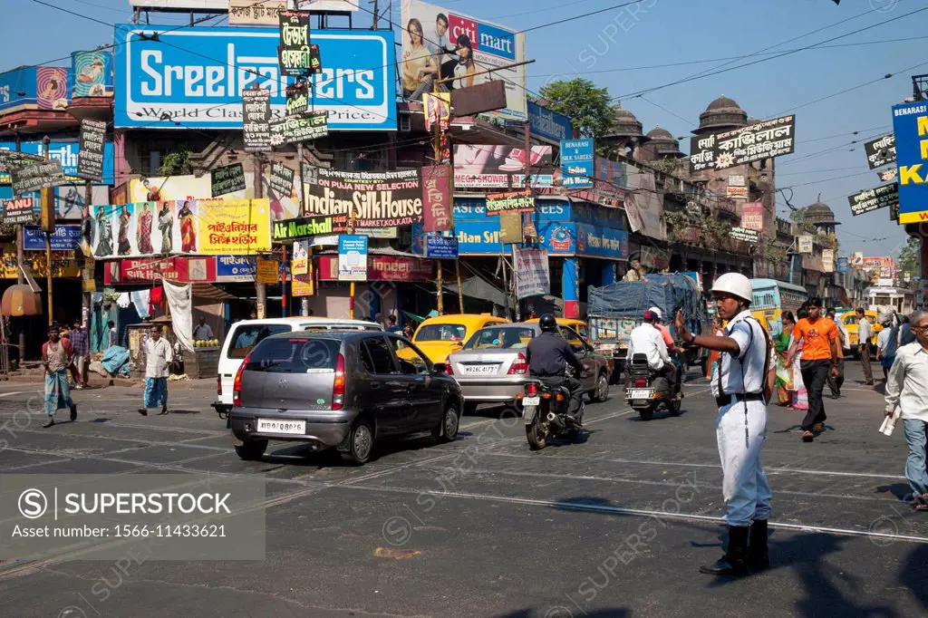 A policeman guides vehicles at the college street junction in Kolkata (Calcutta), West Bengal, India.