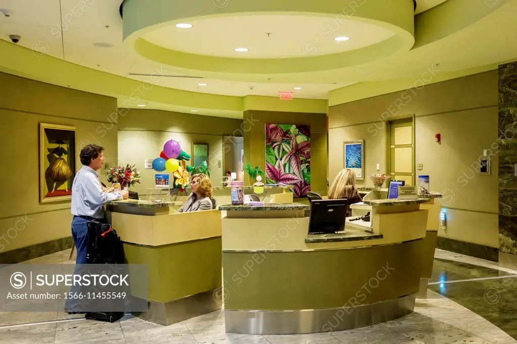 Florida, Miami, International Airport, terminal, concourse, gate area, American Airlines Admirals Club Lounge, receptionist, desk, passenger, getting ...