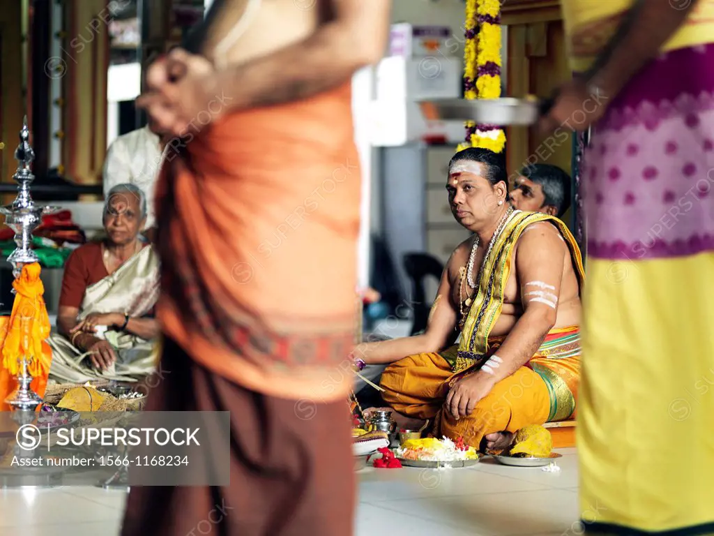 The Chief Priest praying and performing holy rituals inside a Hindu Temple in Malaysia