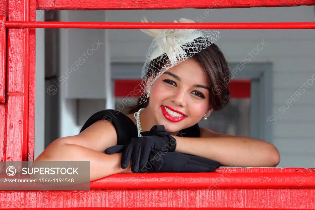 Young woman posing in the window and looking at the camera from one of the trains of the Gold Coast Railroad Museum, Miami, Florida, USA