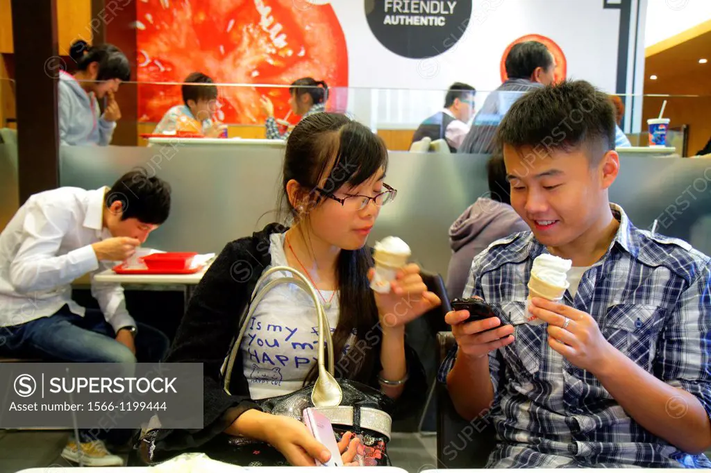 China, Shanghai, Huangpu District, Xizang Road, People´s Square, Raffles City, shopping, Asian, teen, boy, girl, ice cream cone, US company in foreign...