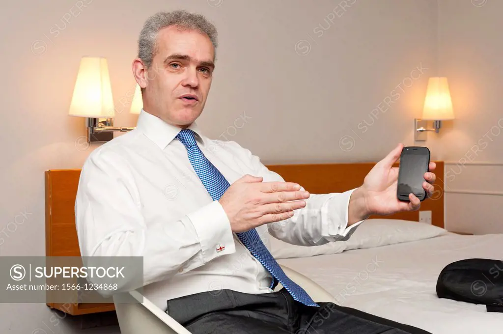 Business man sitting in hotel room in animated conversation