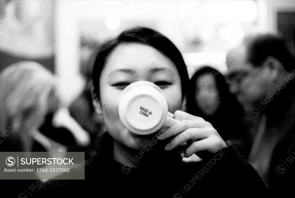 Chinese girl drinking from a mug marked ´Made in China´