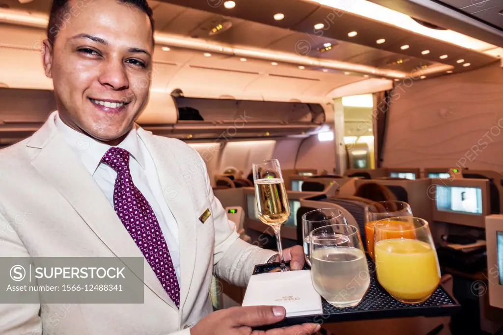 Virginia, Dulles, International Airport, IAD, terminal, Etihad Airways, Business Class, onboard, cabin, Asian, man, flight attendant, offering drinks,...