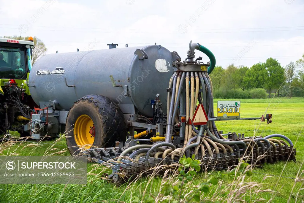 manure injector behind tractor at grassland in holland