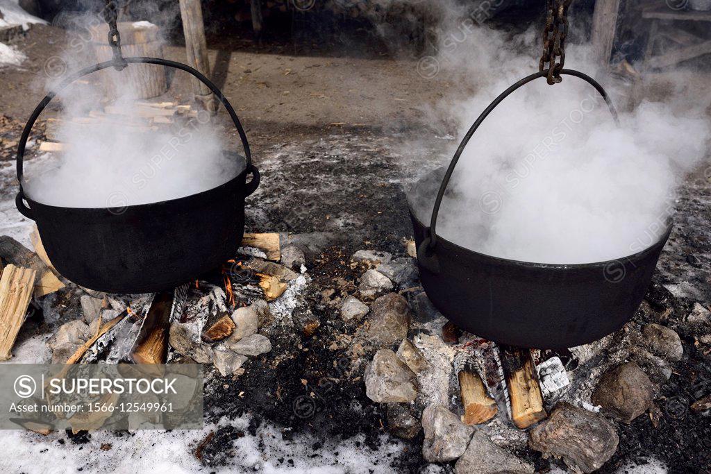 Large cast iron pot being used to reduce sugar maple sap to maple syrup,  traditional reduction method Stock Photo - Alamy