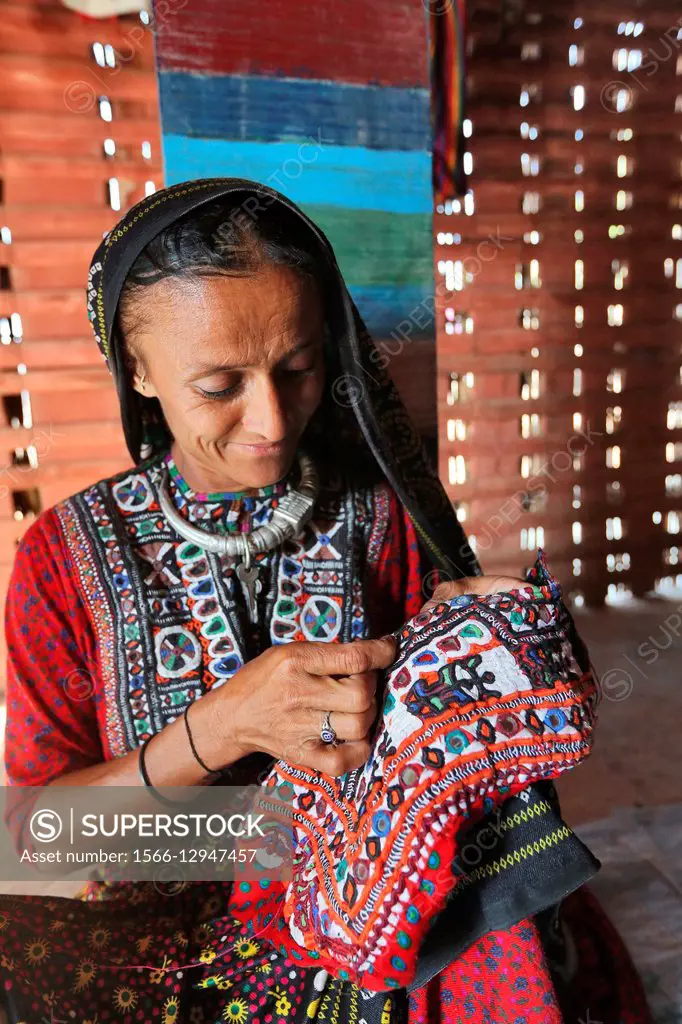 Fakirani Jat tribe, Woman doing embroidery on dress, Kutch District, Gujarat, India.