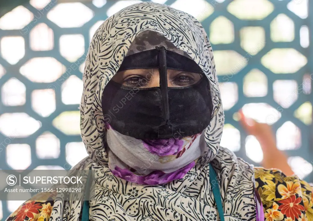 Iran, Hormozgan, Bandar Abbas, a bandari woman wearing the traditional mask called the burqa on a market.