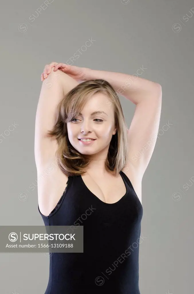 Beautiful young woman stretching her triceps.