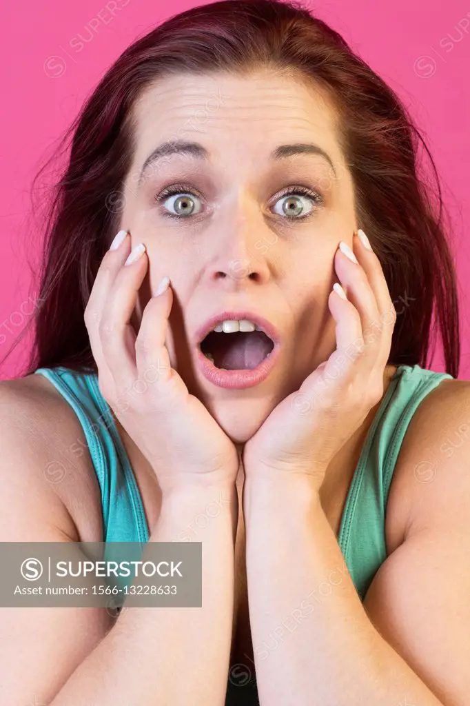Surprised woman hands on face.