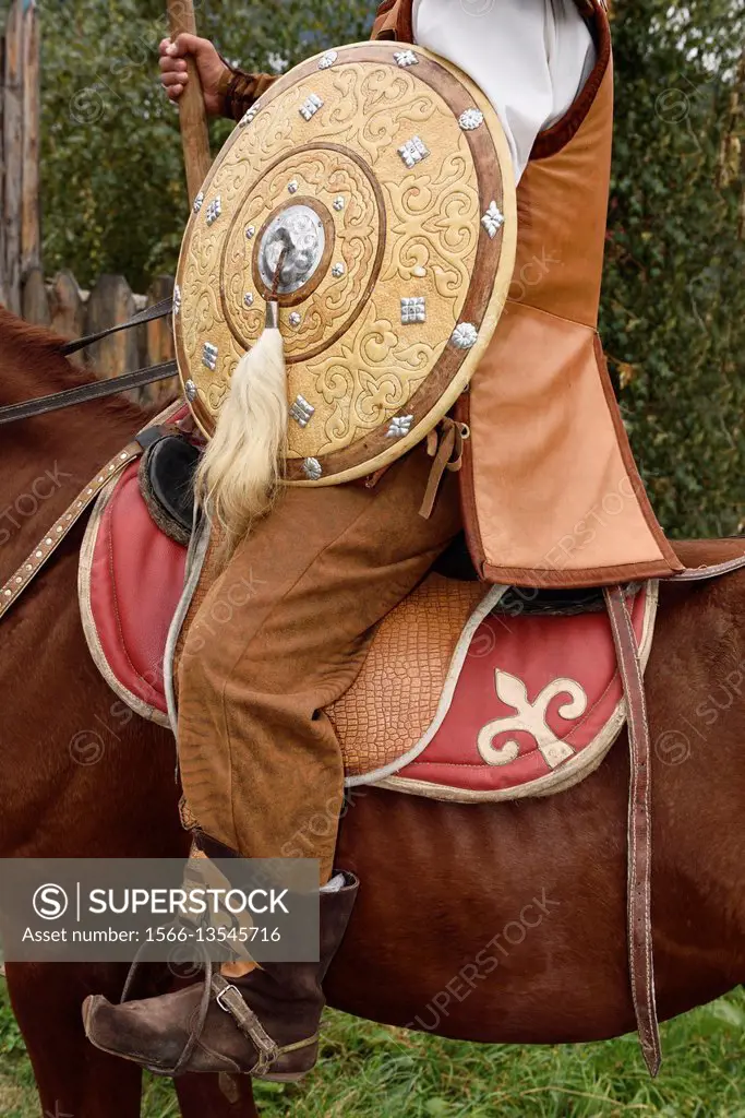 Detail of guard in traditional hun clothes with shield and spear on horseback Kazakhstan.