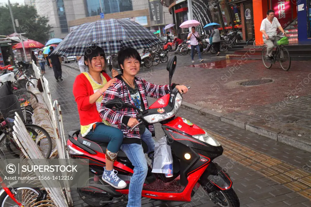 China, Beijing, Xicheng District, Guang An Men Nei Da Jie, Guanganmen Inner Street, Asian, man, woman, couple, umbrella, weather, electric motor scoot...