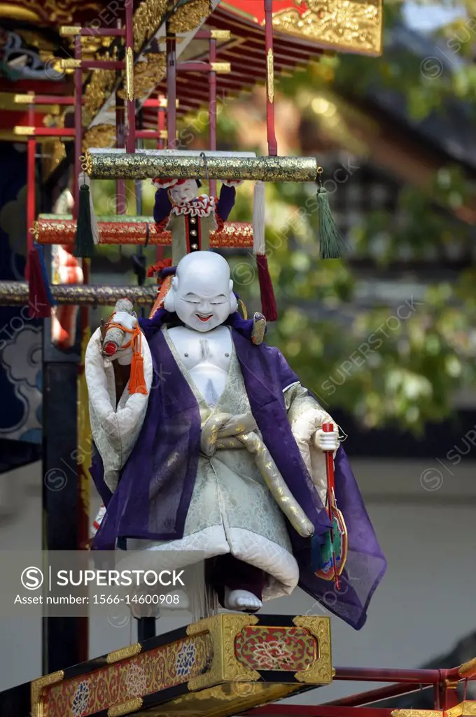 A mechanical marionette or puppet sits an ornate traditional wooden float during the Takayama festival in Japan,Asia.