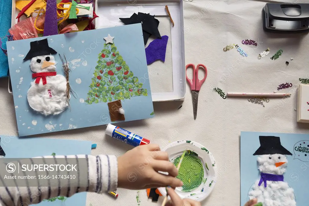 Hands of a 10 year old girl doing a Christmas craft. Horizontal shot.