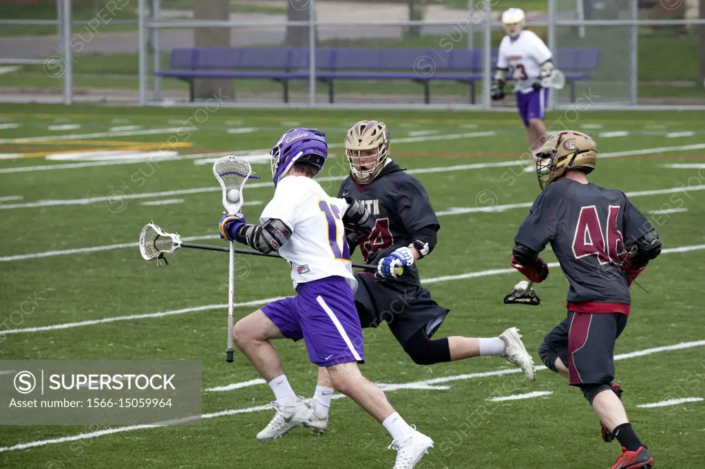 Cretin-Derham Hall High School lacrosse player runs against opposition with ball cradled in stick head St Paul Minnesota MN USA.