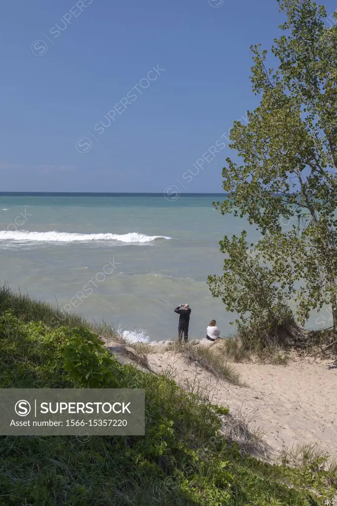 Beverly Shores, Indiana - A man and woman on the beach at Indiana Dunes National Lakeshore, at the southern end of Lake Michigan.