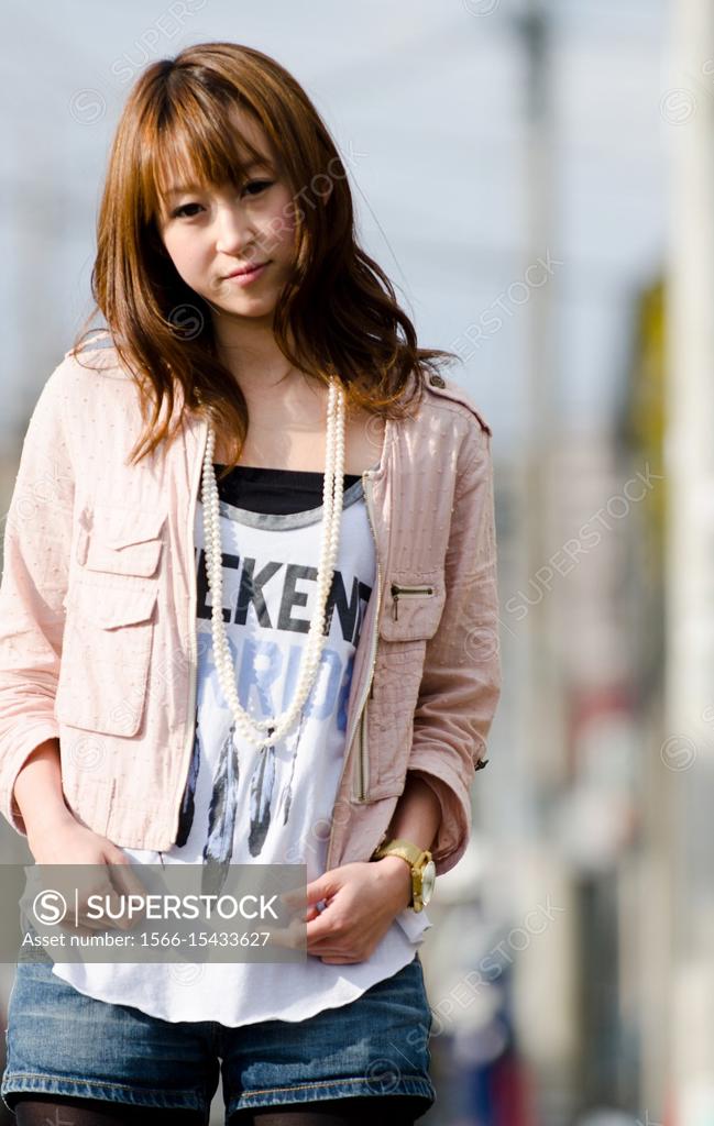 Japanese Girl poses on the street in Jiyugaoka, Japan. Jiyugaoka is a town  located in Tokyo. - SuperStock