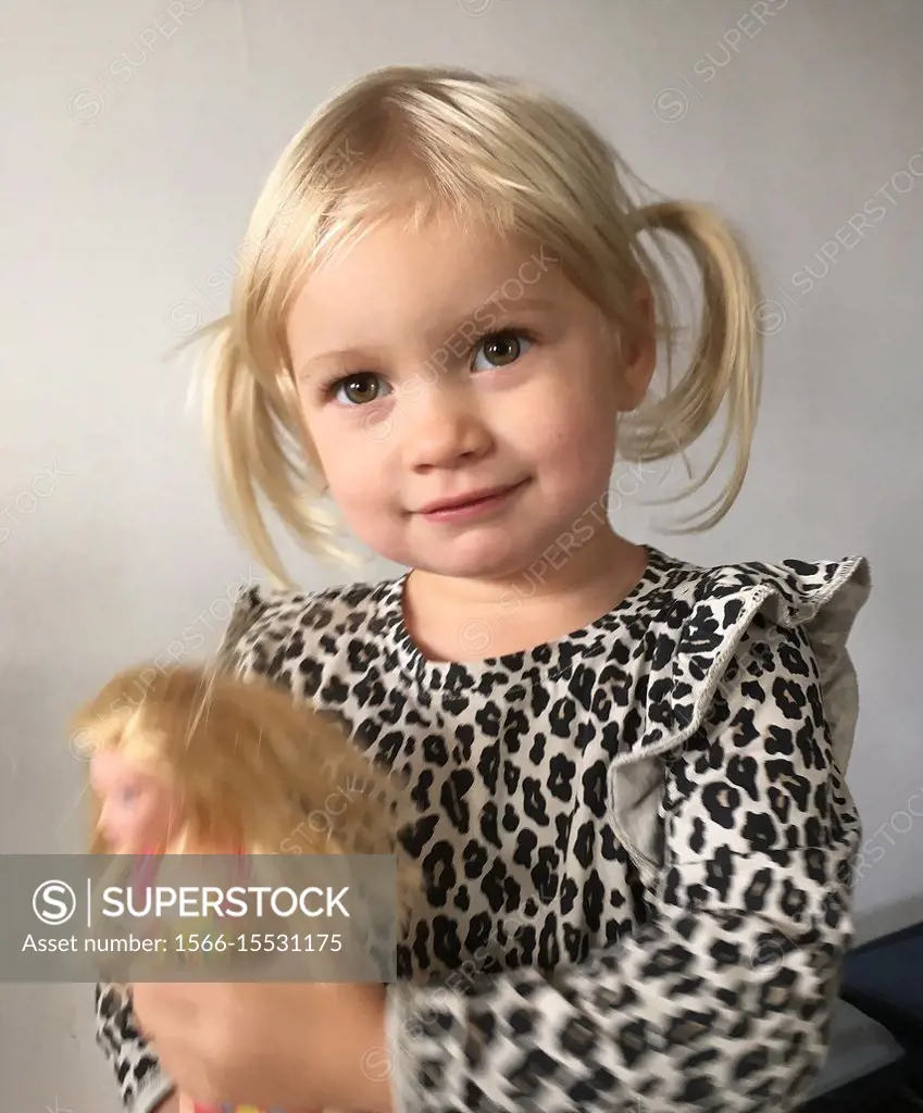 Portrait on a little blond girl with a toy, 2 1/2 years old, in Ystad, Scania, Sweden.