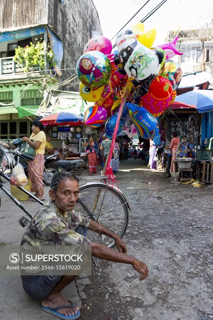 Myanmar (formerly Burma). Mon State. Mawlamyine (Moulmein). Balloon salesman in the street