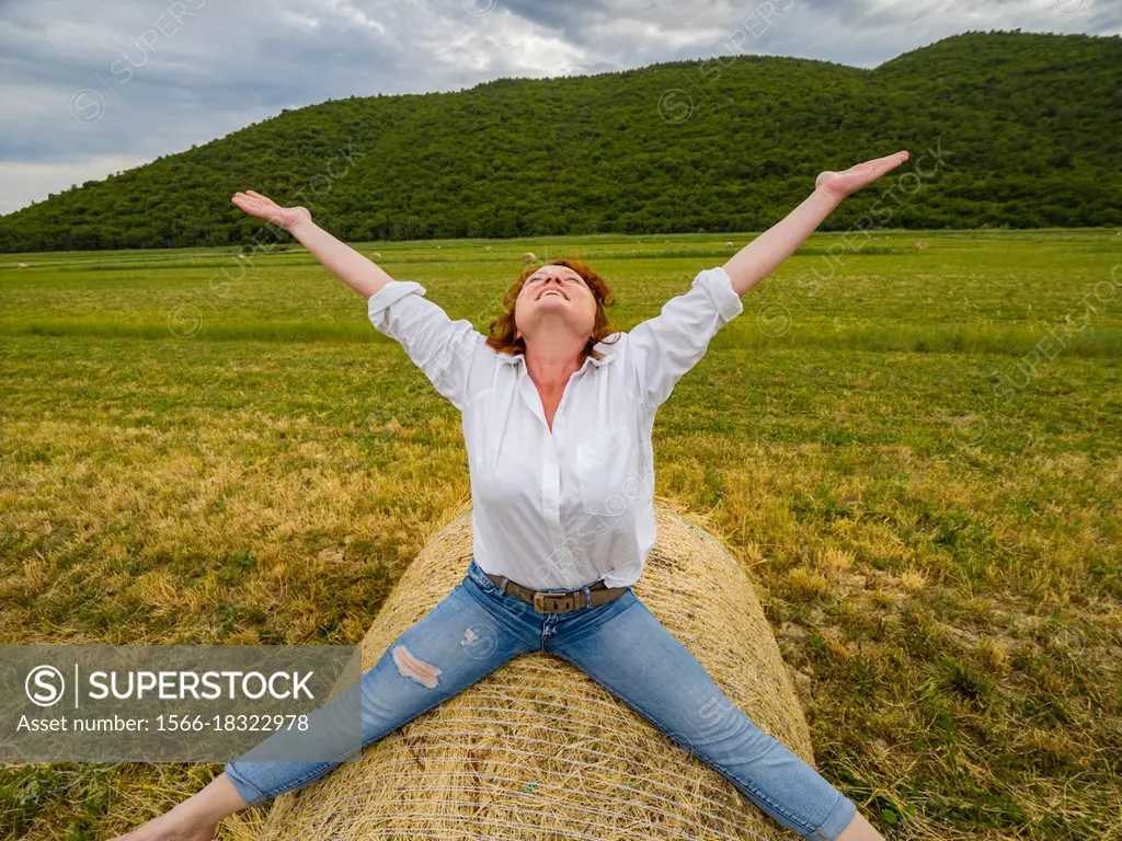 Joy of life mature woman spreading wide on countryside haystack looking up joy of life